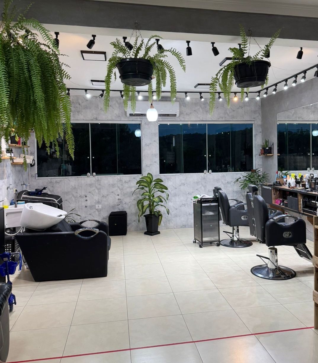O salão do Studio Martinelli no Jardim Santa Fé: cadeiras de barbeiro, lavatório e paredes de mármore